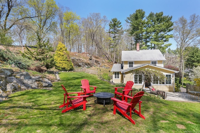 view of yard with fence, a fire pit, and a patio area