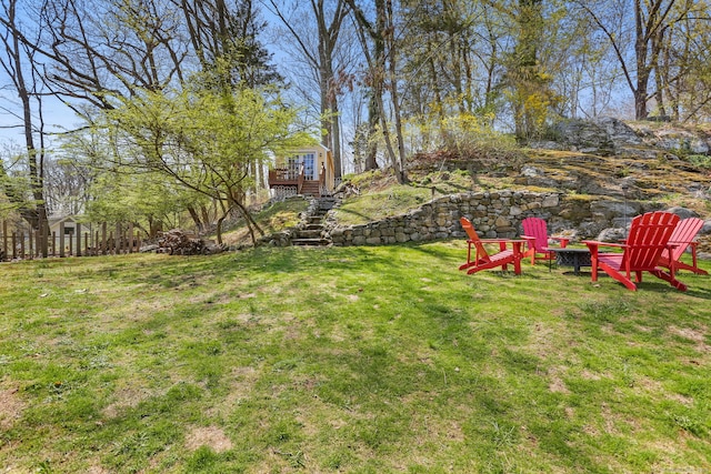 view of yard featuring stairs, an outdoor fire pit, and a deck