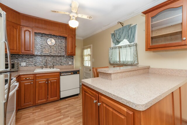 kitchen with brown cabinets, dishwasher, range, and a sink