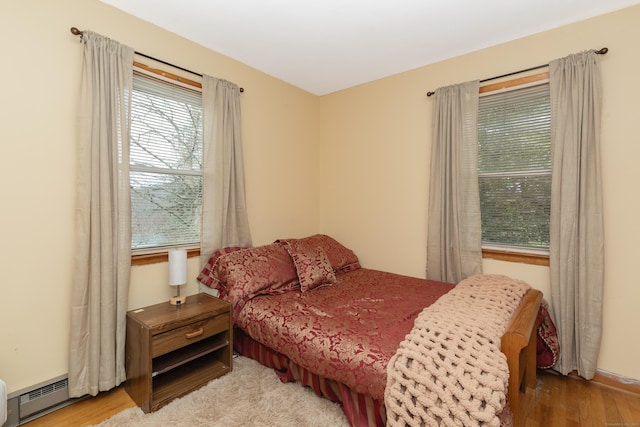 bedroom featuring a baseboard radiator and wood finished floors