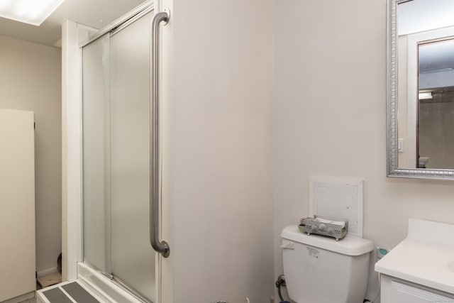bathroom with vanity, toilet, and a stall shower