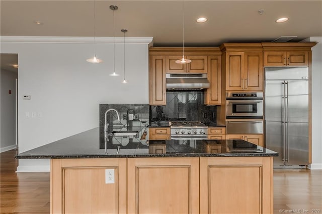 85 Memorial Rd Apt 414, West Hartford, CT 06107 - kitchen with baseboards, light wood-style floors, backsplash, under cabinet range hood, and appliances with stainless steel finishes