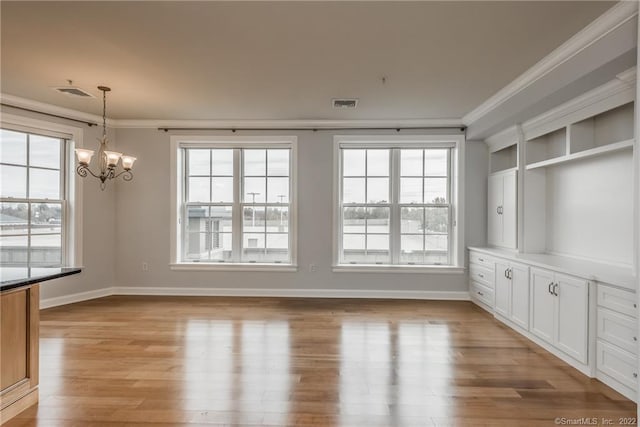 85 Memorial Rd Apt 414, West Hartford, CT 06107 - unfurnished dining area featuring a chandelier, light wood-style floors, visible vents, and crown molding