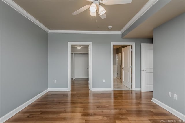 85 Memorial Rd Apt 414, West Hartford, CT 06107 - unfurnished bedroom with baseboards, wood finished floors, a closet, crown molding, and a walk in closet