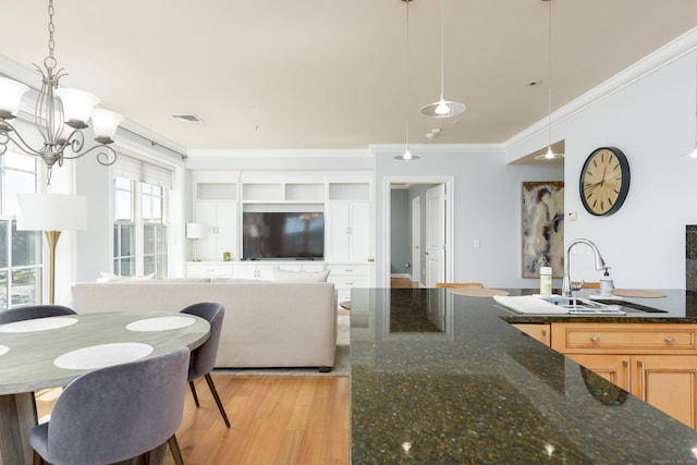 85 Memorial Rd Apt 414, West Hartford, CT 06107 - kitchen featuring crown molding, a sink, an inviting chandelier, light wood-style flooring, and visible vents