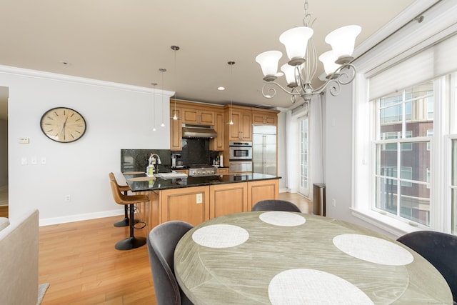 85 Memorial Rd Apt 414, West Hartford, CT 06107 - dining room featuring light wood-type flooring, a healthy amount of sunlight, baseboards, and a notable chandelier