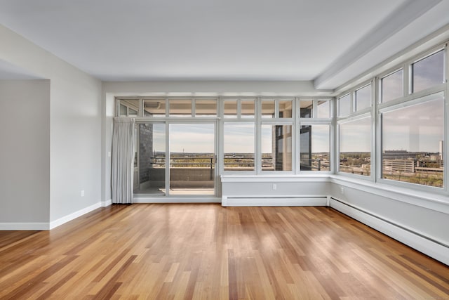 interior space featuring light wood-style flooring, baseboard heating, and baseboards