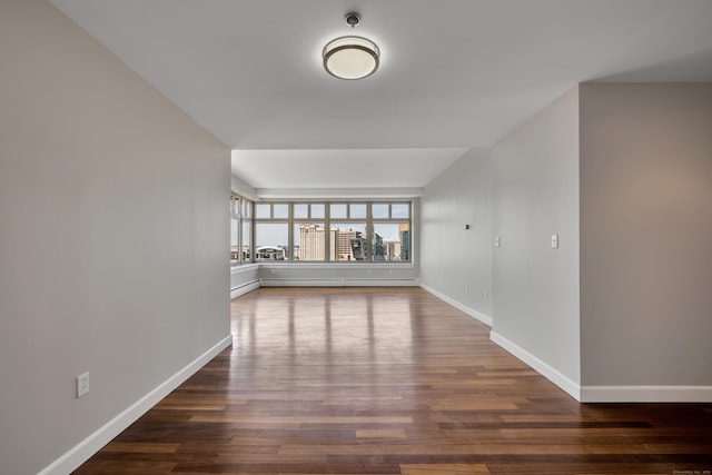 spare room with wood finished floors and baseboards