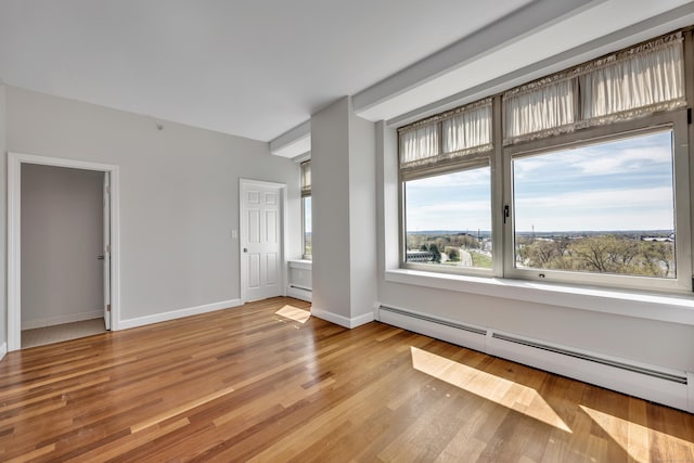 interior space featuring baseboards, light wood-style flooring, and a baseboard radiator