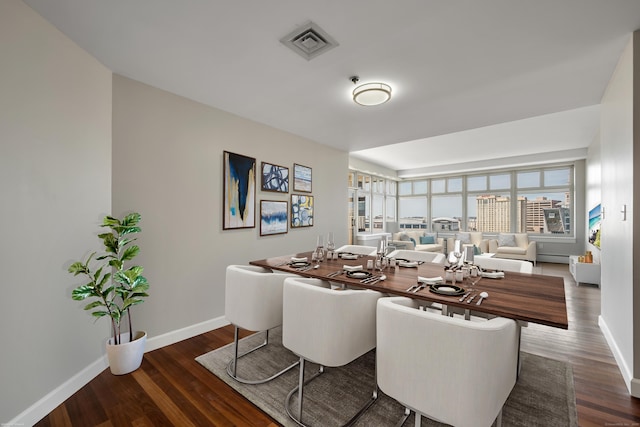 dining area with baseboards, visible vents, and wood finished floors