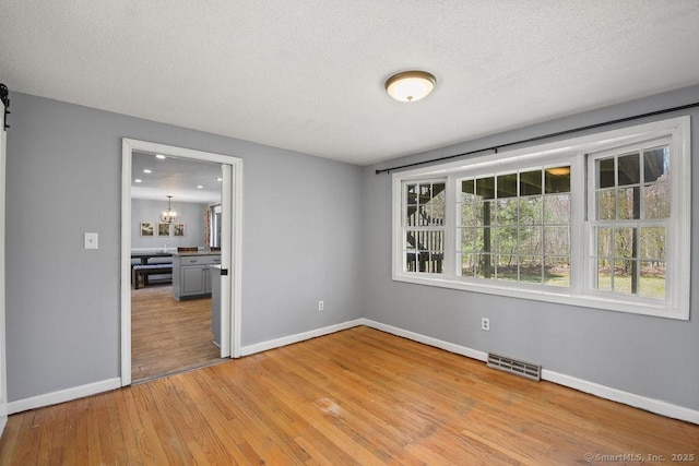 8 Gregory Ln, Simsbury, CT 06070 - spare room featuring baseboards, visible vents, a textured ceiling, and light wood finished floors