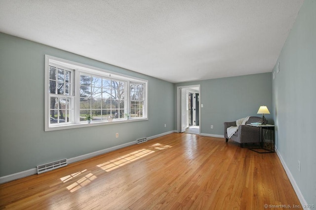 8 Gregory Ln, Simsbury, CT 06070 - unfurnished living room featuring wood finished floors, visible vents, and baseboards