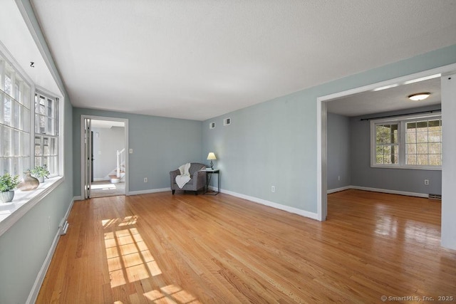 8 Gregory Ln, Simsbury, CT 06070 - unfurnished living room featuring visible vents, light wood finished floors, and baseboards