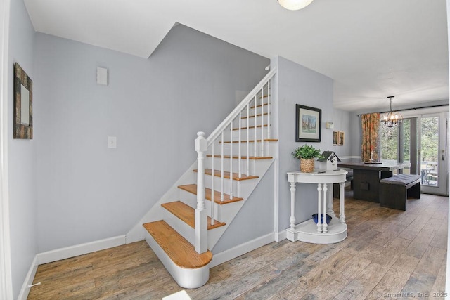 8 Gregory Ln, Simsbury, CT 06070 - stairs featuring a chandelier, wood finished floors, and baseboards