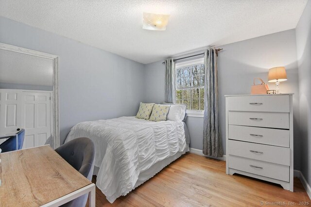 8 Gregory Ln, Simsbury, CT 06070 - bedroom with baseboards, a textured ceiling, and light wood-style flooring