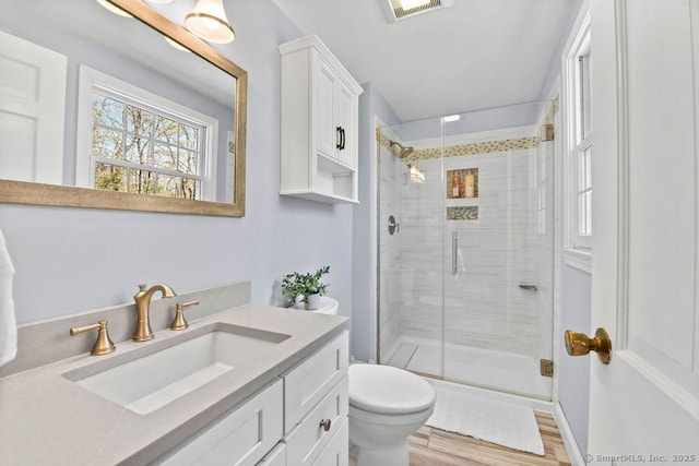 8 Gregory Ln, Simsbury, CT 06070 - bathroom with wood finished floors, a shower stall, toilet, vanity, and visible vents