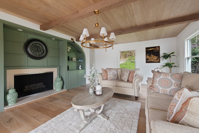 living room with wood ceiling, a large fireplace, wood finished floors, beamed ceiling, and a notable chandelier