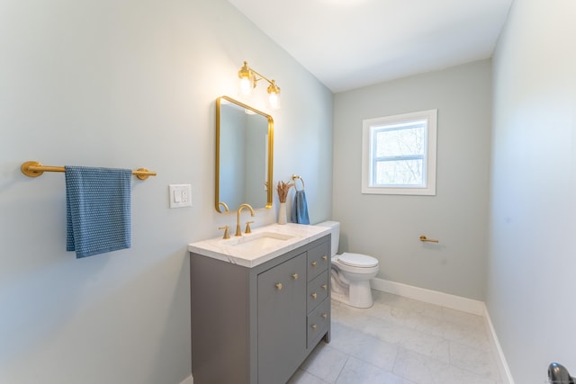 bathroom with vanity, baseboards, toilet, and marble finish floor