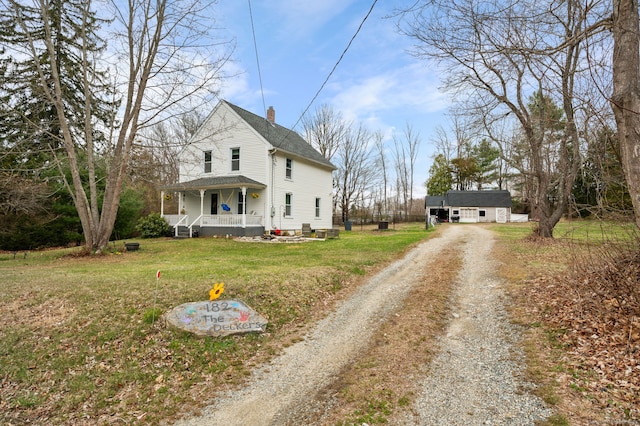 exterior space featuring an outbuilding, a porch, a shingled roof, dirt driveway, and a front yard