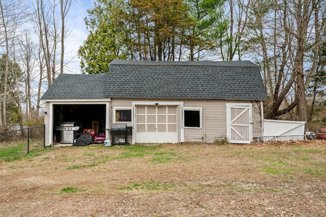 view of outbuilding featuring fence and an outdoor structure