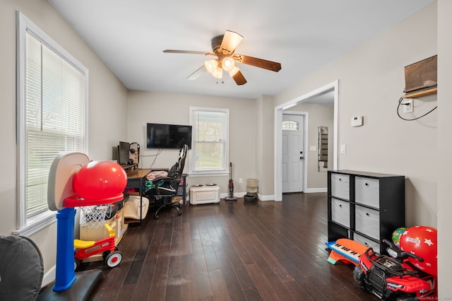 recreation room with baseboards, hardwood / wood-style flooring, and ceiling fan