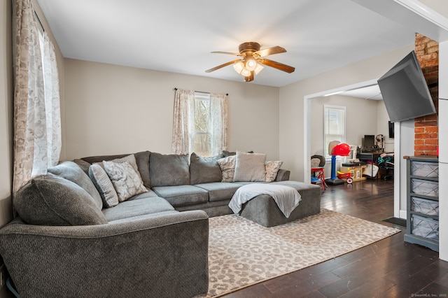 living area featuring ceiling fan and dark wood-style floors