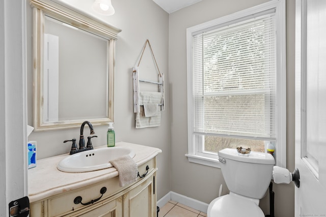 half bath featuring vanity, toilet, baseboards, and tile patterned floors