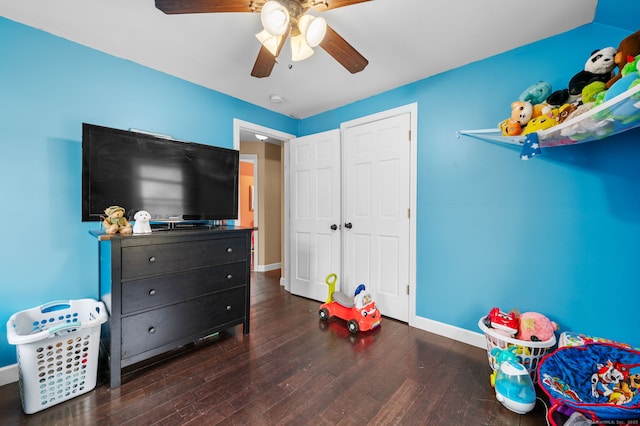 recreation room with hardwood / wood-style floors, a ceiling fan, and baseboards