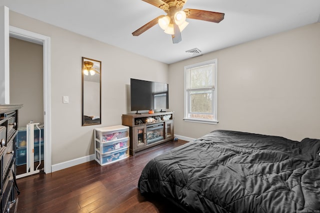 bedroom featuring visible vents, hardwood / wood-style flooring, baseboards, and a ceiling fan