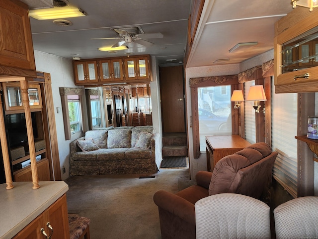 living area with carpet floors and a ceiling fan
