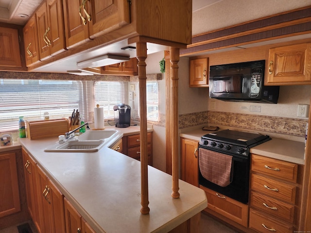 kitchen with light countertops, a sink, brown cabinets, and black appliances