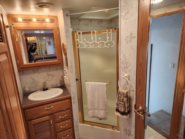 full bath featuring vanity, enclosed tub / shower combo, and wallpapered walls