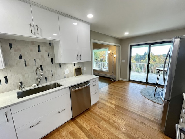 205 Arch Bridge Rd, Bethlehem, CT 06751 - kitchen featuring stainless steel appliances, a sink, white cabinetry, backsplash, and light countertops