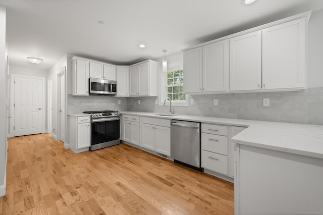 54 Edgerton Rd, Granby, CT 06090 - kitchen with stainless steel appliances, tasteful backsplash, light wood-style floors, white cabinetry, and recessed lighting