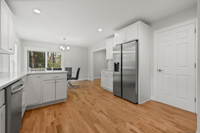 54 Edgerton Rd, Granby, CT 06090 - kitchen with appliances with stainless steel finishes, white cabinetry, light countertops, a chandelier, and light wood-type flooring