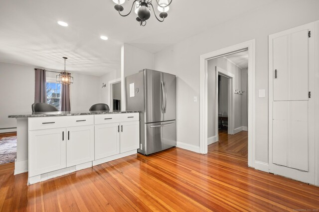16 Academy St, Manchester, CT 06040 - kitchen featuring a peninsula, a notable chandelier, light wood-style floors, and freestanding refrigerator
