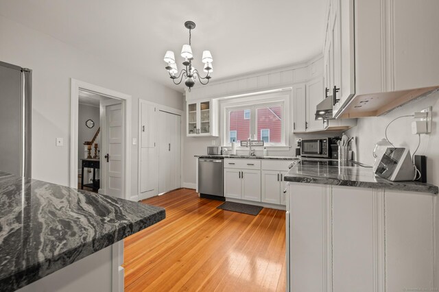 16 Academy St, Manchester, CT 06040 - kitchen with light wood-type flooring, an inviting chandelier, pendant lighting, white cabinets, and appliances with stainless steel finishes
