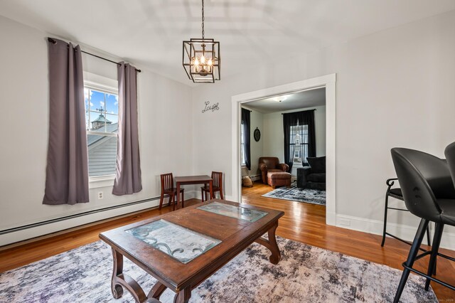 16 Academy St, Manchester, CT 06040 - living area featuring an inviting chandelier, wood finished floors, a wealth of natural light, and a baseboard radiator