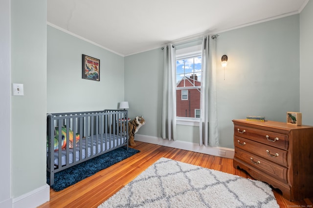 16 Academy St, Manchester, CT 06040 - bedroom with baseboards, a nursery area, wood finished floors, and ornamental molding