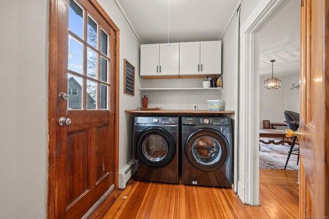 16 Academy St, Manchester, CT 06040 - clothes washing area featuring a baseboard radiator, light wood-style floors, washing machine and dryer, and cabinet space