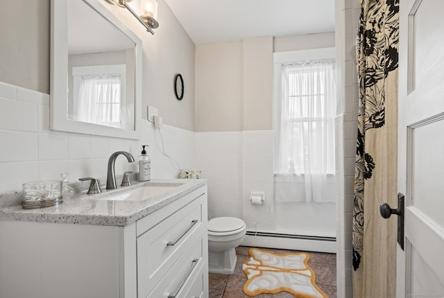16 Academy St, Manchester, CT 06040 - bathroom featuring baseboard heating, vanity, tile walls, a wainscoted wall, and toilet