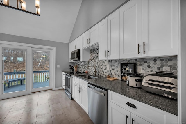 394 Woodhaven Rd, Glastonbury, CT 06033 - kitchen featuring dark stone counters, a sink, stainless steel appliances, backsplash, and lofted ceiling