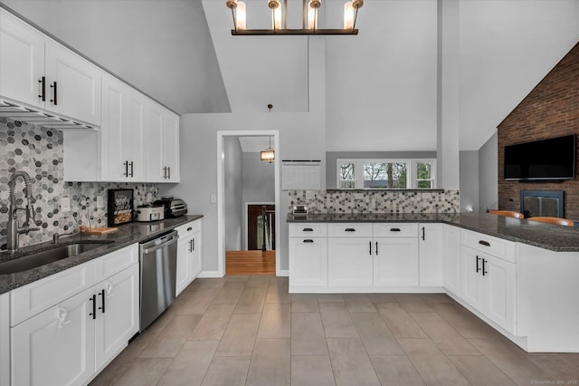 394 Woodhaven Rd, Glastonbury, CT 06033 - kitchen with dark stone countertops, stainless steel dishwasher, a sink, tasteful backsplash, and high vaulted ceiling