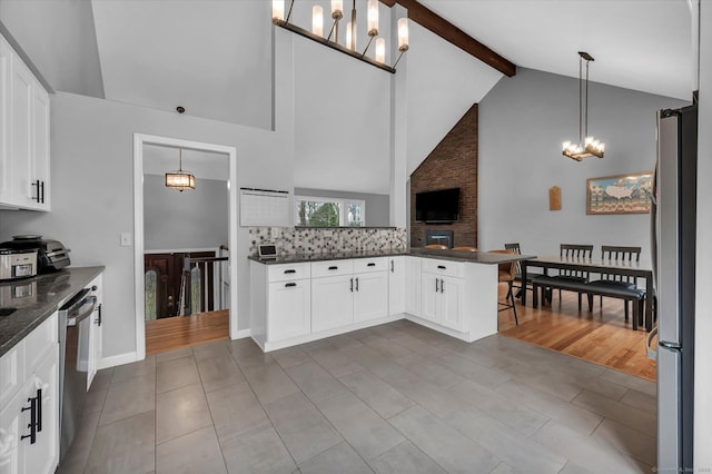 394 Woodhaven Rd, Glastonbury, CT 06033 - kitchen featuring white cabinets, stainless steel appliances, an inviting chandelier, beamed ceiling, and high vaulted ceiling