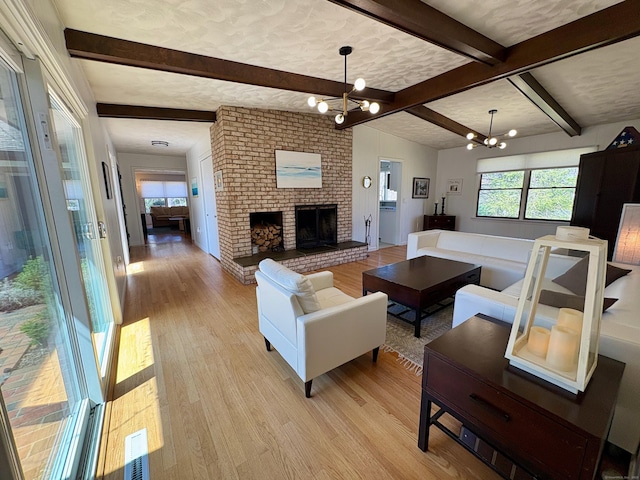 64 Sherwood Ln, Norwich, CT 06360 - living room with a fireplace, an inviting chandelier, light wood-style flooring, and beam ceiling