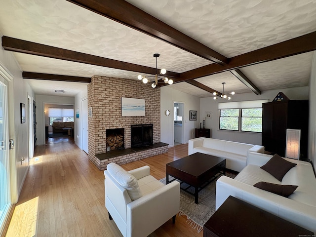 64 Sherwood Ln, Norwich, CT 06360 - living room with baseboards, light wood finished floors, an inviting chandelier, a brick fireplace, and beamed ceiling