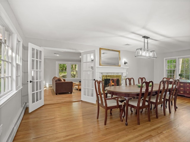 44 Buckingham Ridge Rd, Wilton, CT 06897 - dining room with baseboard heating, french doors, light wood-type flooring, a premium fireplace, and a baseboard heating unit