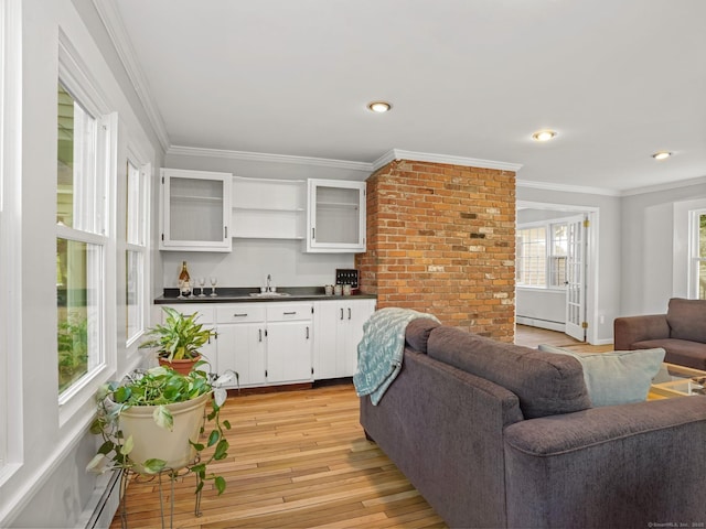44 Buckingham Ridge Rd, Wilton, CT 06897 - living area featuring bar with sink, baseboard heating, light wood-style flooring, ornamental molding, and recessed lighting