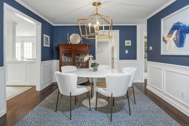 dining space featuring a decorative wall, an inviting chandelier, a wainscoted wall, and dark wood-type flooring