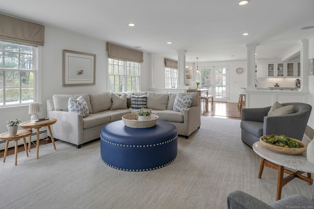 living room with recessed lighting, a healthy amount of sunlight, and decorative columns